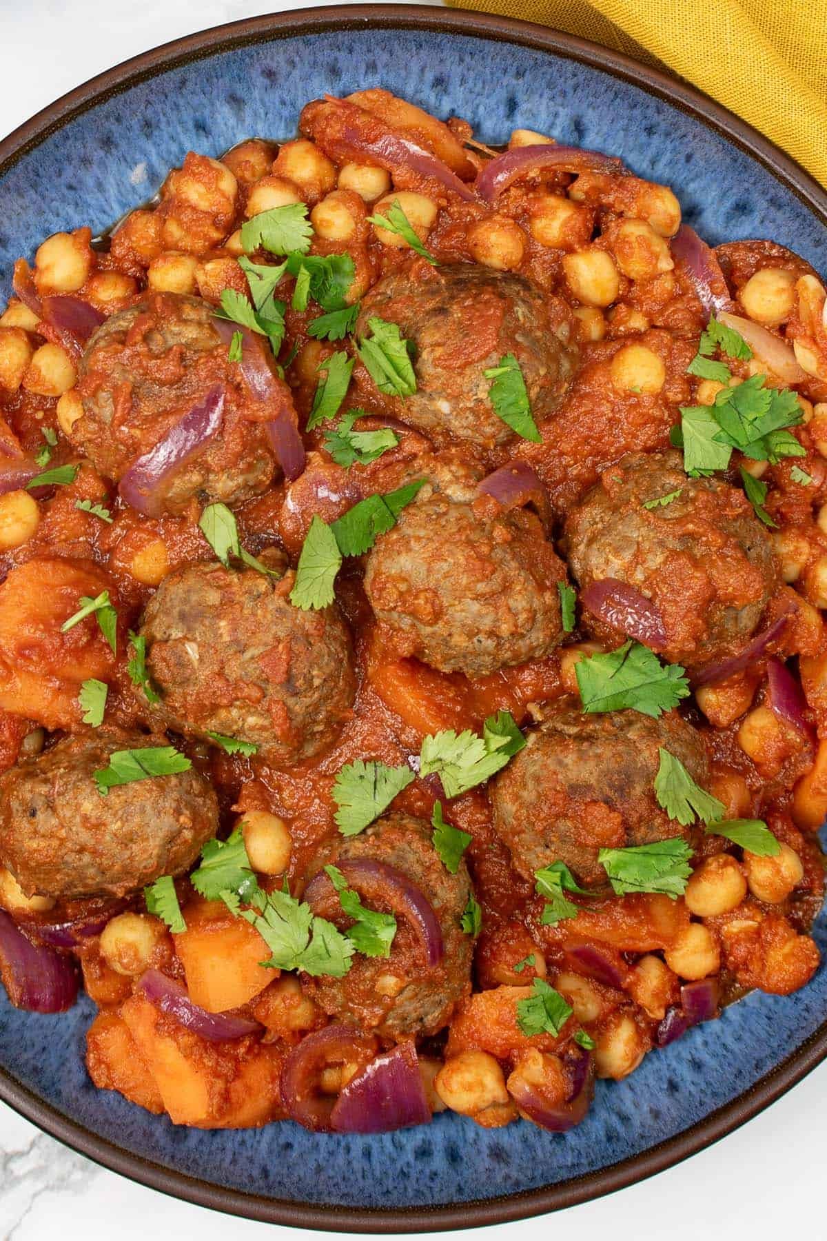 Close up of lamb meatball tagine in a blue patterned bowl.