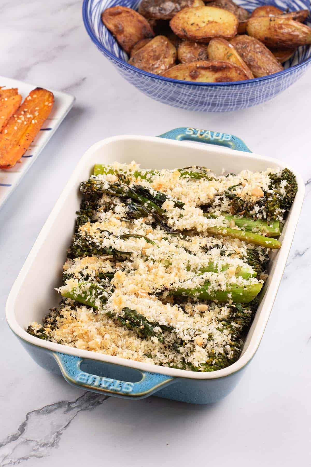 Roast tenderstem broccoli with parmesan and pine nut crumb in a Staub dish with za'atar carrots and sautéed potatoes on the side.