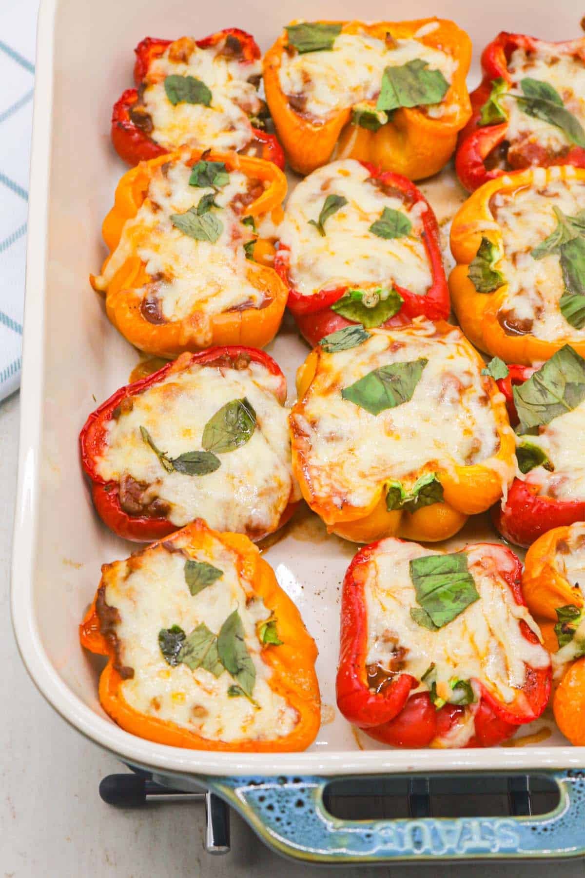 Bolognese stuffed peppers in large Staub rectangle oven dish.