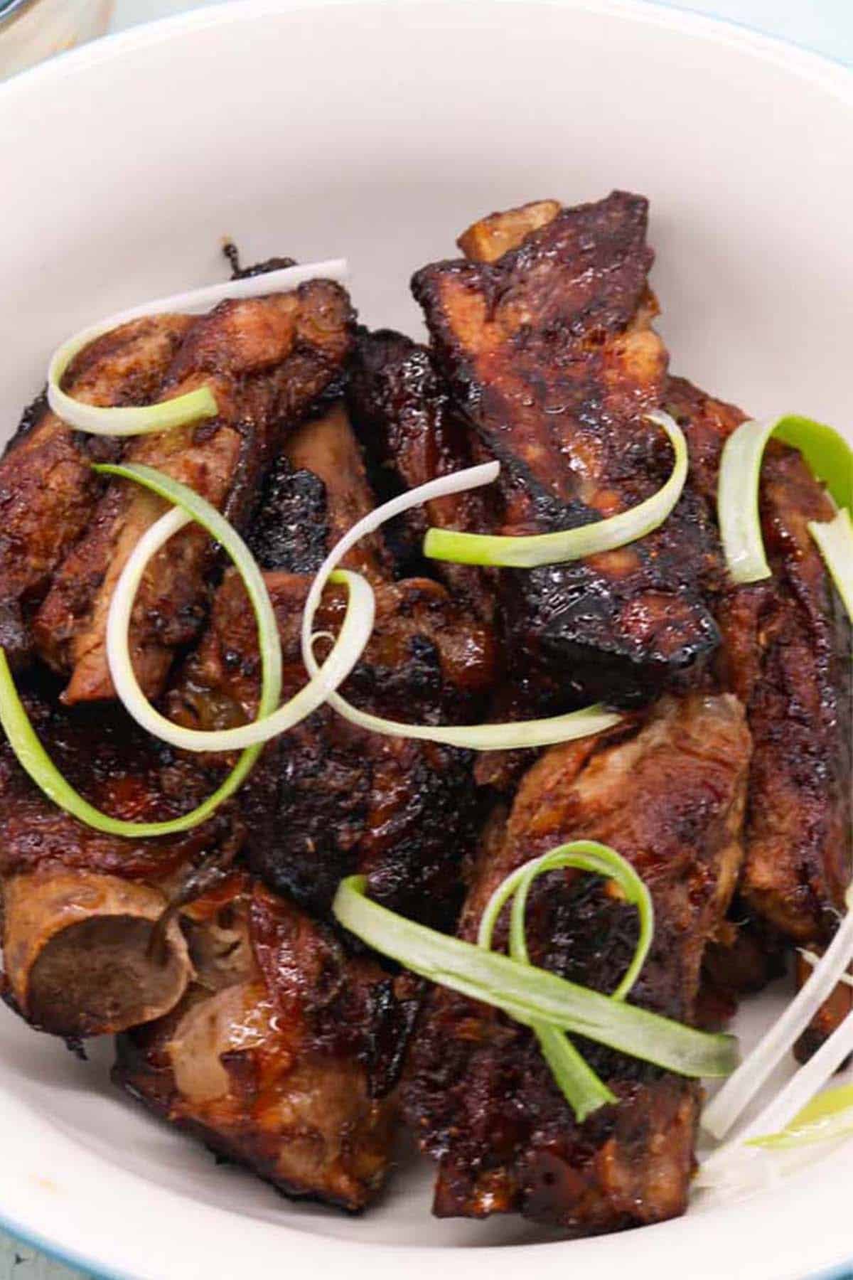 Close up of char sui pork ribs in a serving bowl.