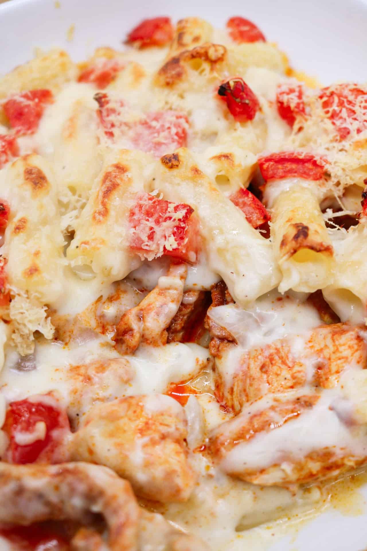 Close up of chicken pasta bake in a white square oven dish.