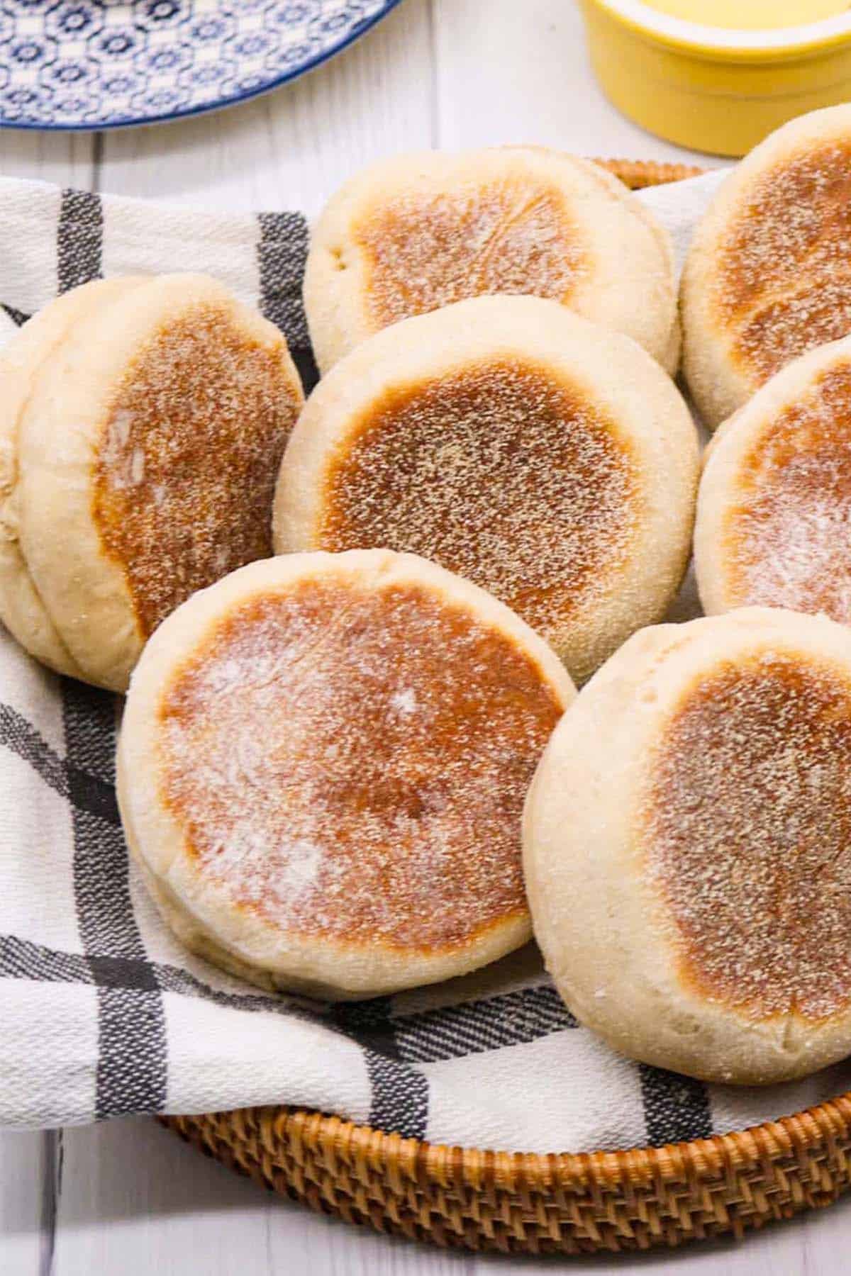 English muffins on black and white towel in bread basket
