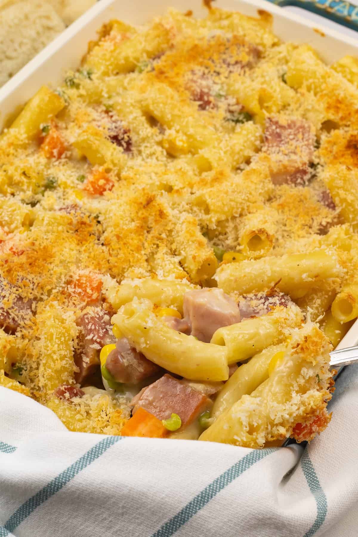 Close up of ham and vegetable pasta bake in a rectangle Staub dish.
