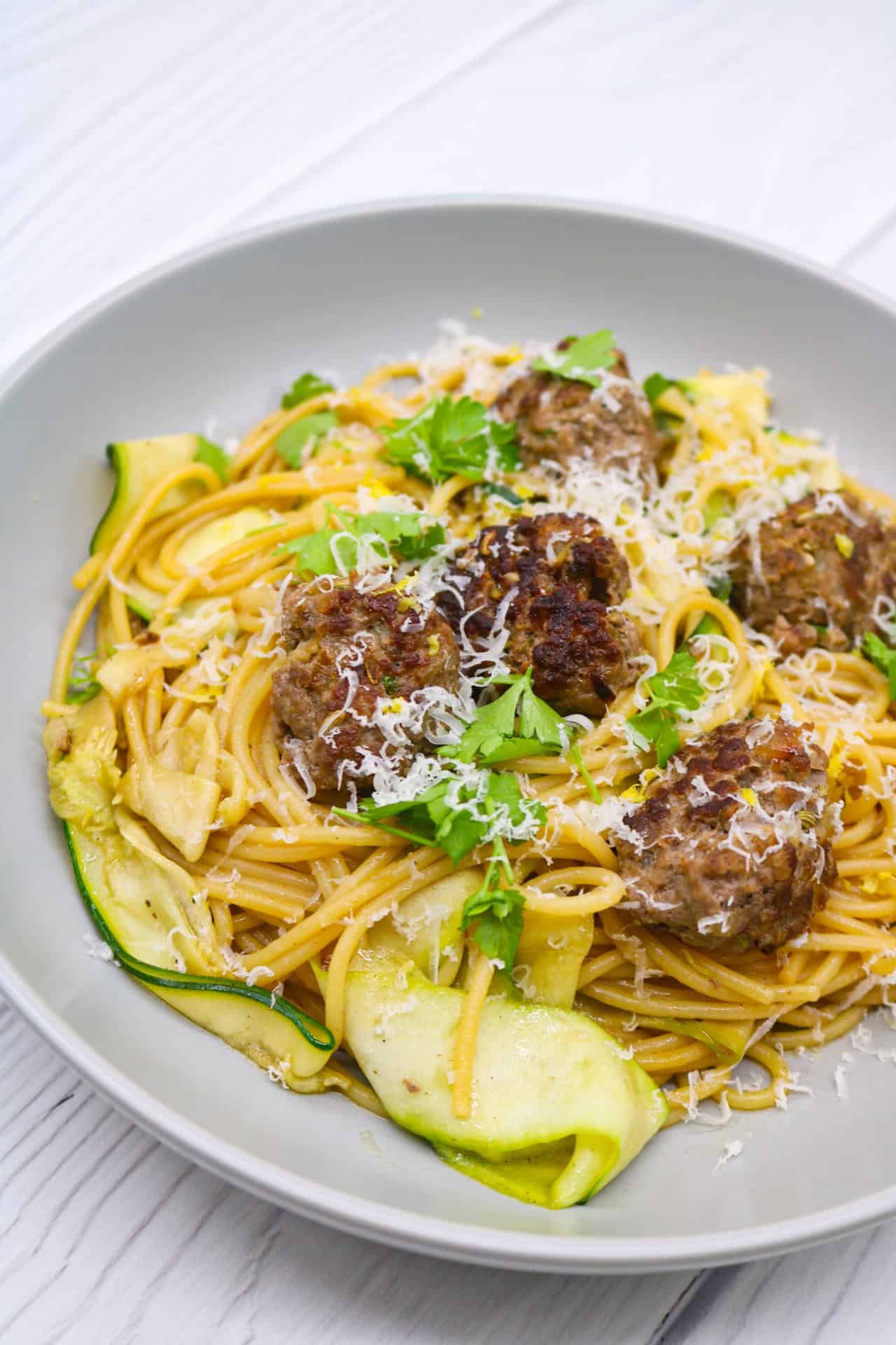 Summer meatballs and spaghetti in a grey bowl.