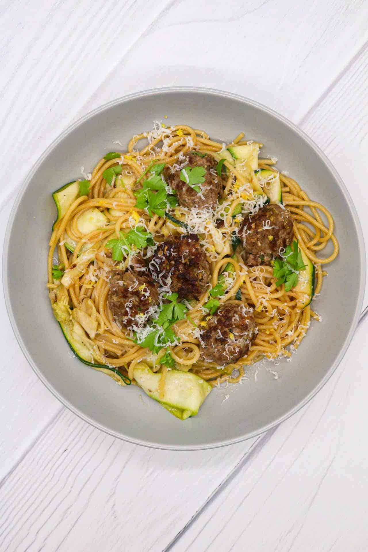 Summer meatballs and spaghetti in a grey bowl.