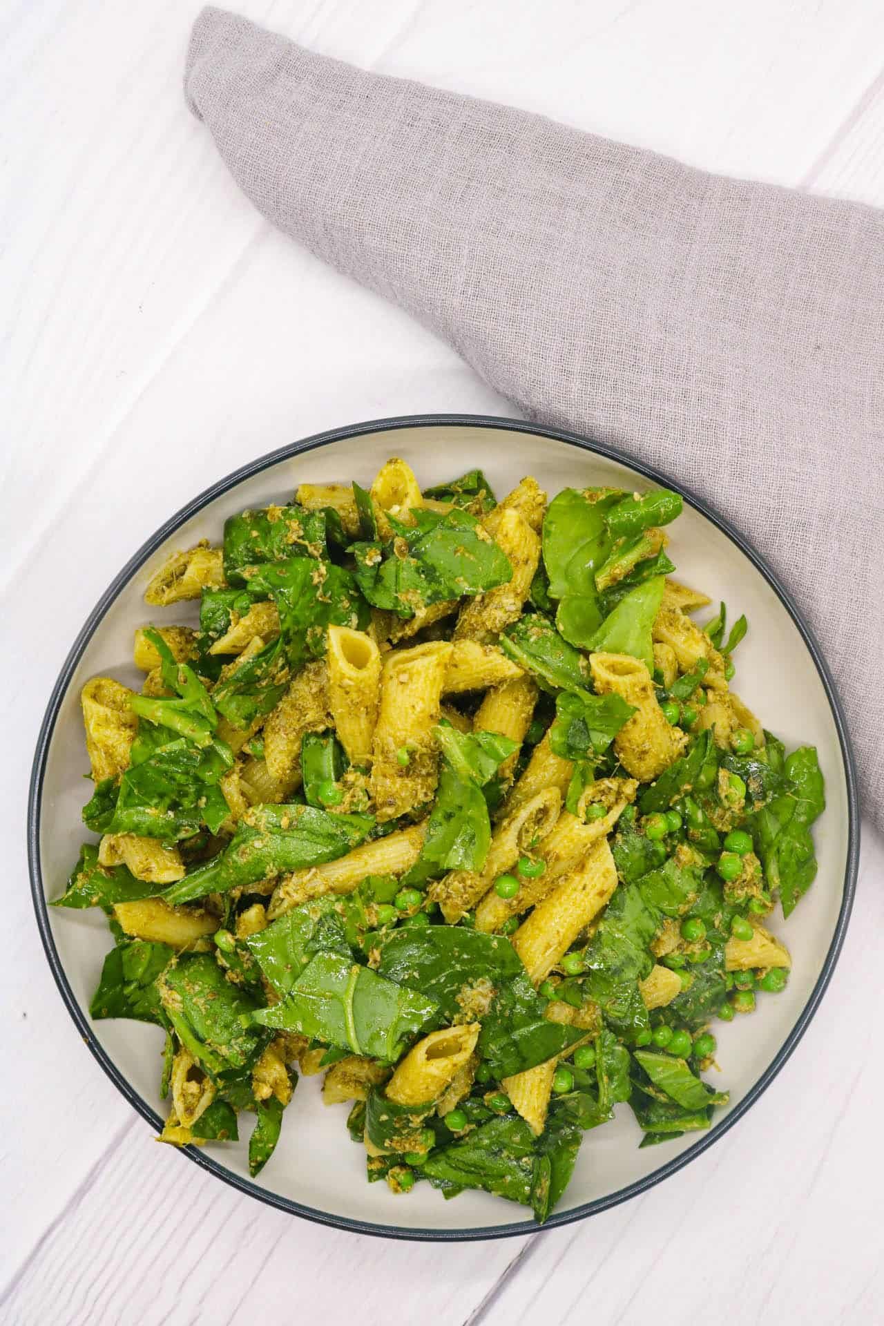 Pesto, peas and spinach pasta salad in large bowl