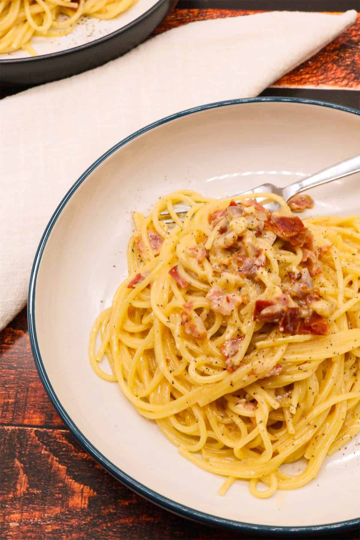 Spaghetti carbonara in bowl with fork