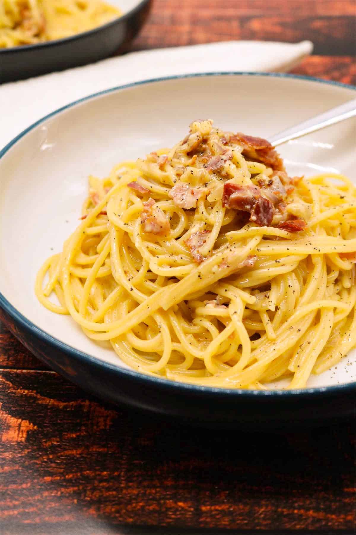 Spaghetti carbonara in bowl with fork