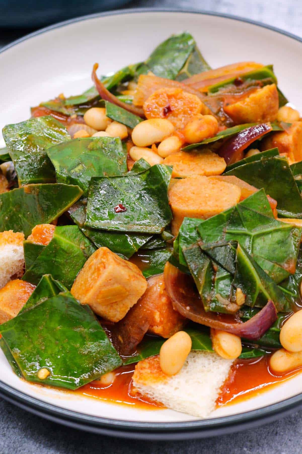 Close up of a bowl of vegan sausage and white bean stew.