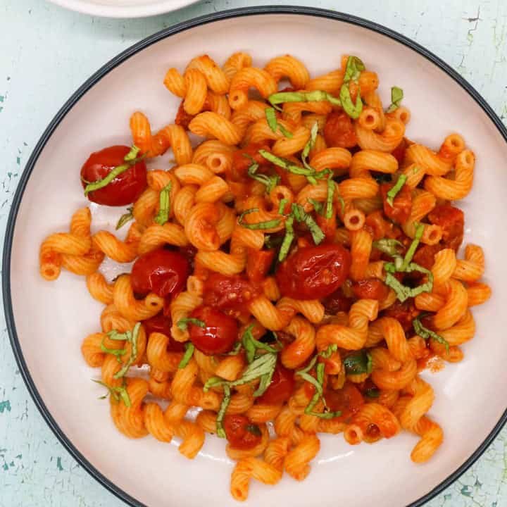 Chorizo and chilli pepper pasta in a black and cream bowl.