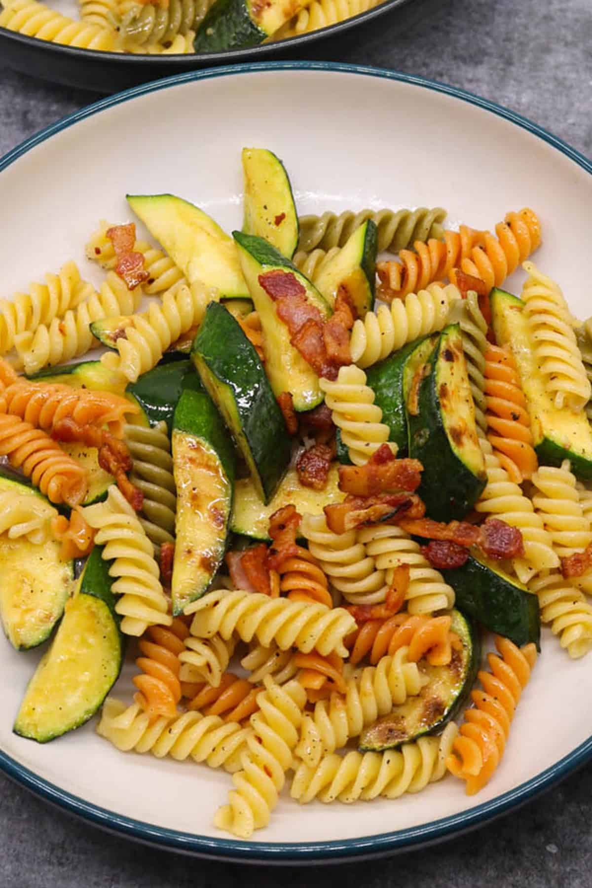 Chargrilled courgette and smoked bacon pasta in a pasta bowl.