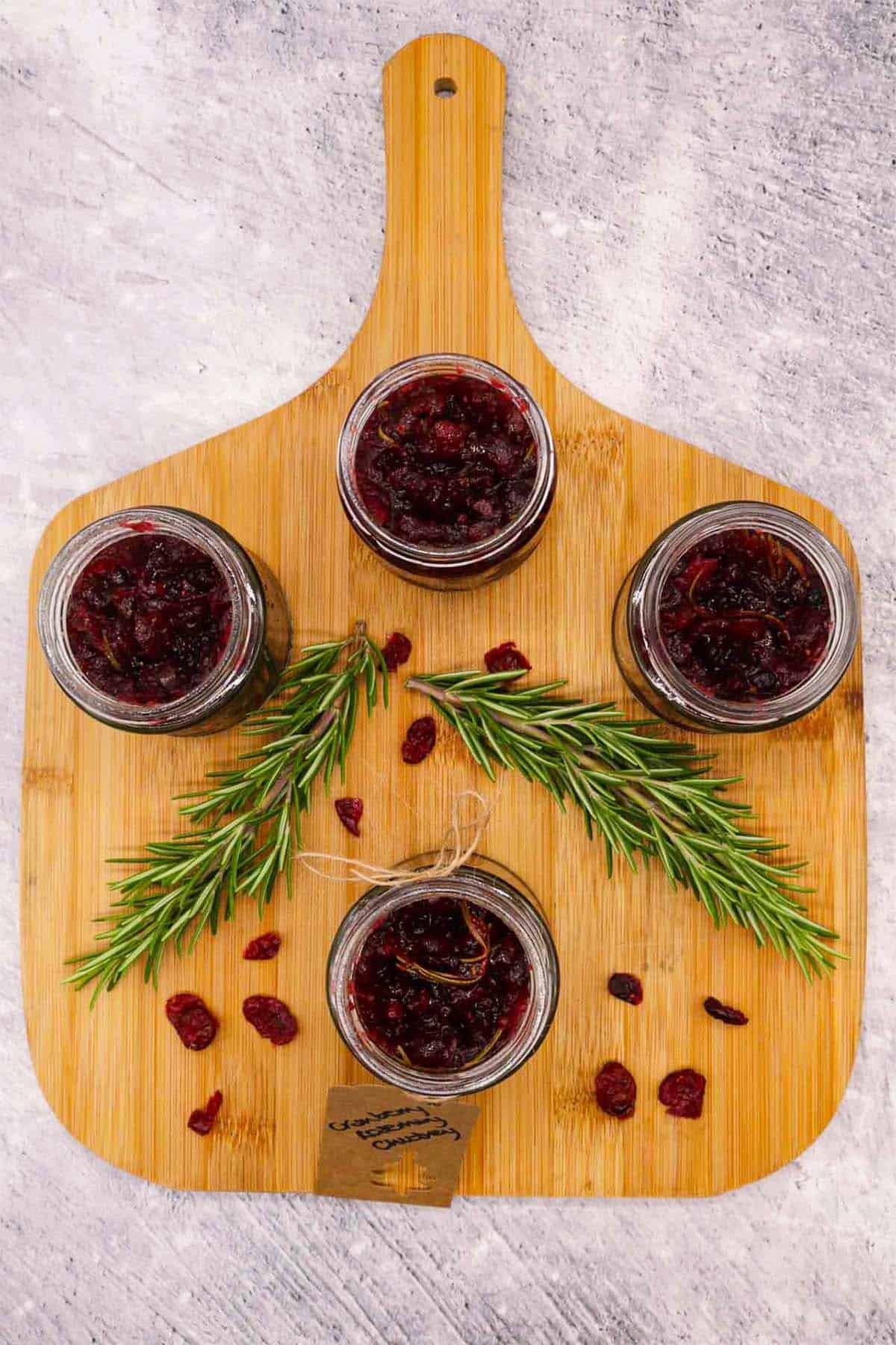 Four jars of cranberry and rosemary jam with gift label