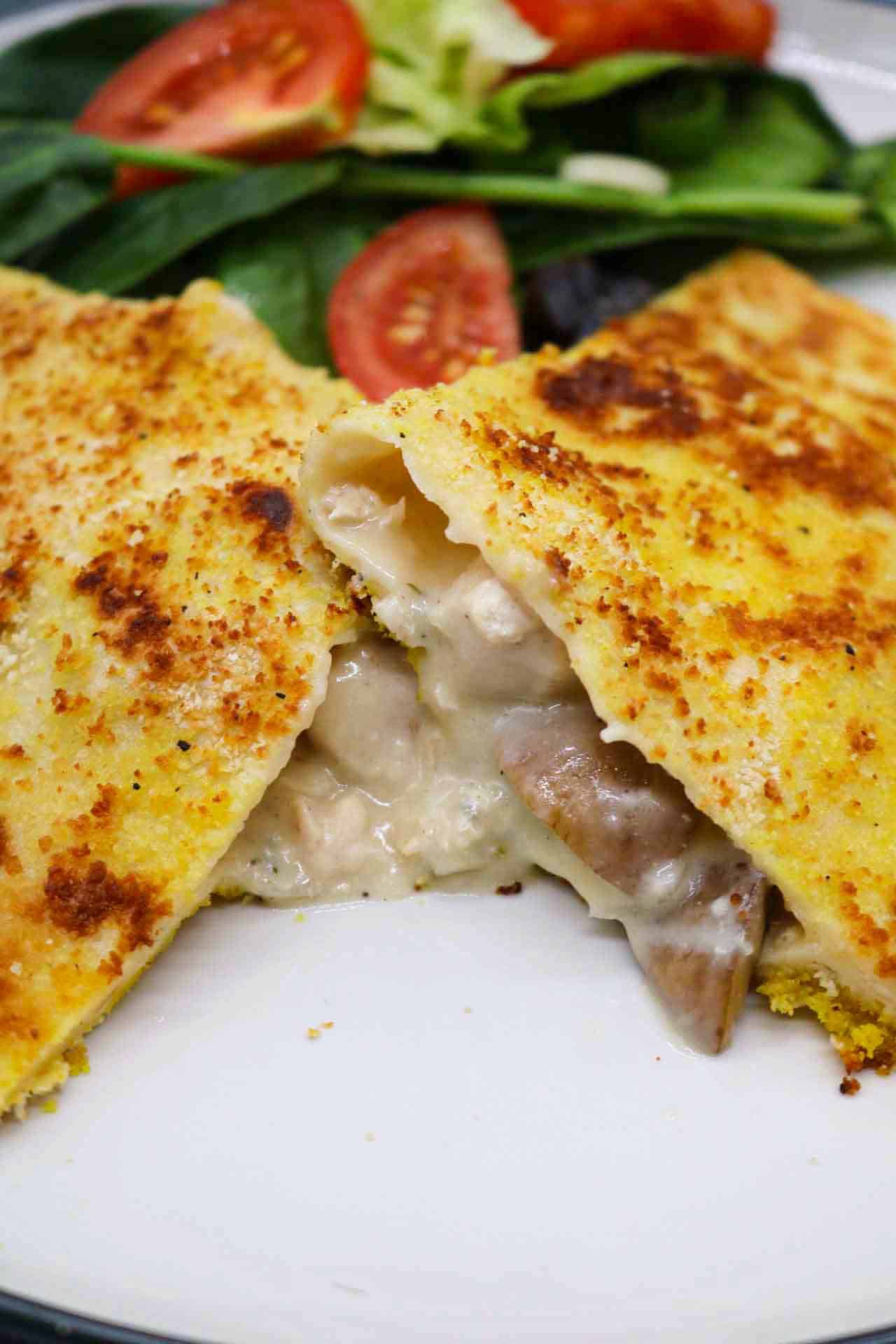 Creamy chicken and mushroom crispy pancake on plate with salad leaves
