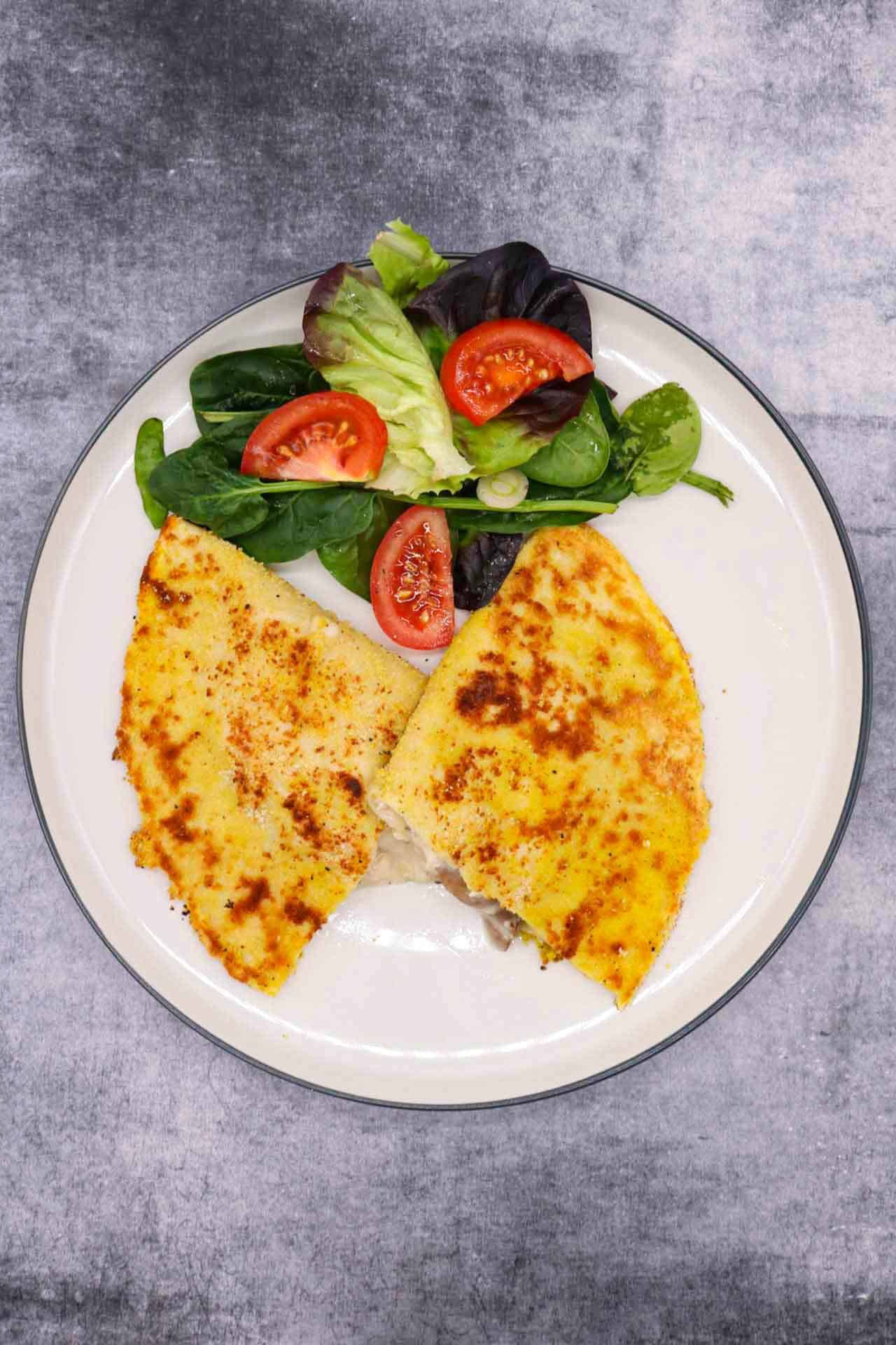 Creamy chicken and mushroom crispy pancake on plate with salad leaves