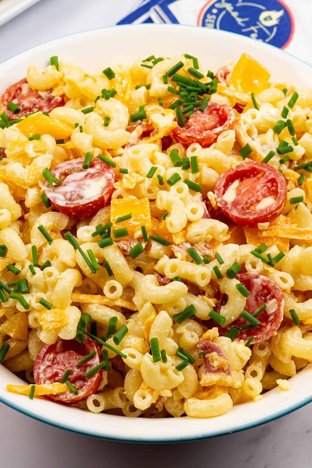 Close up of mac 'n' cheese salad in a round serving bowl.