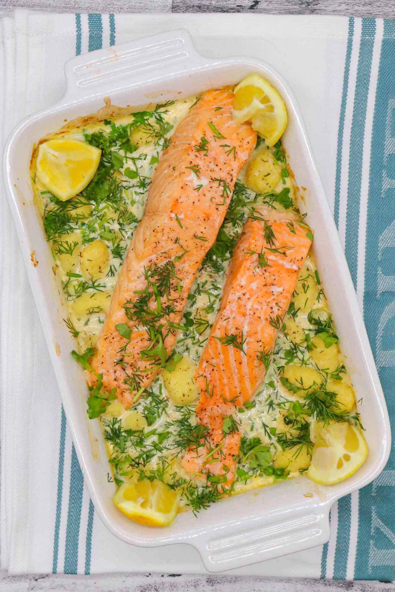 Salmon and gnocchi in rectangle serving dish with lemon wedges