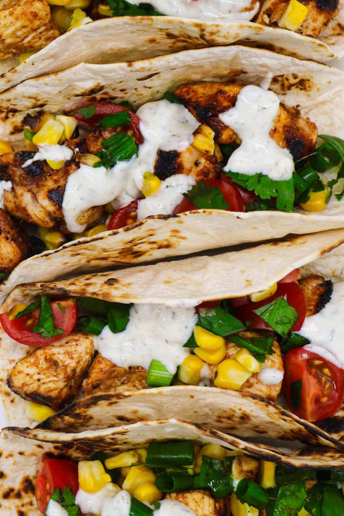 Chicken and corn in flour tortillas on white oval serving platter