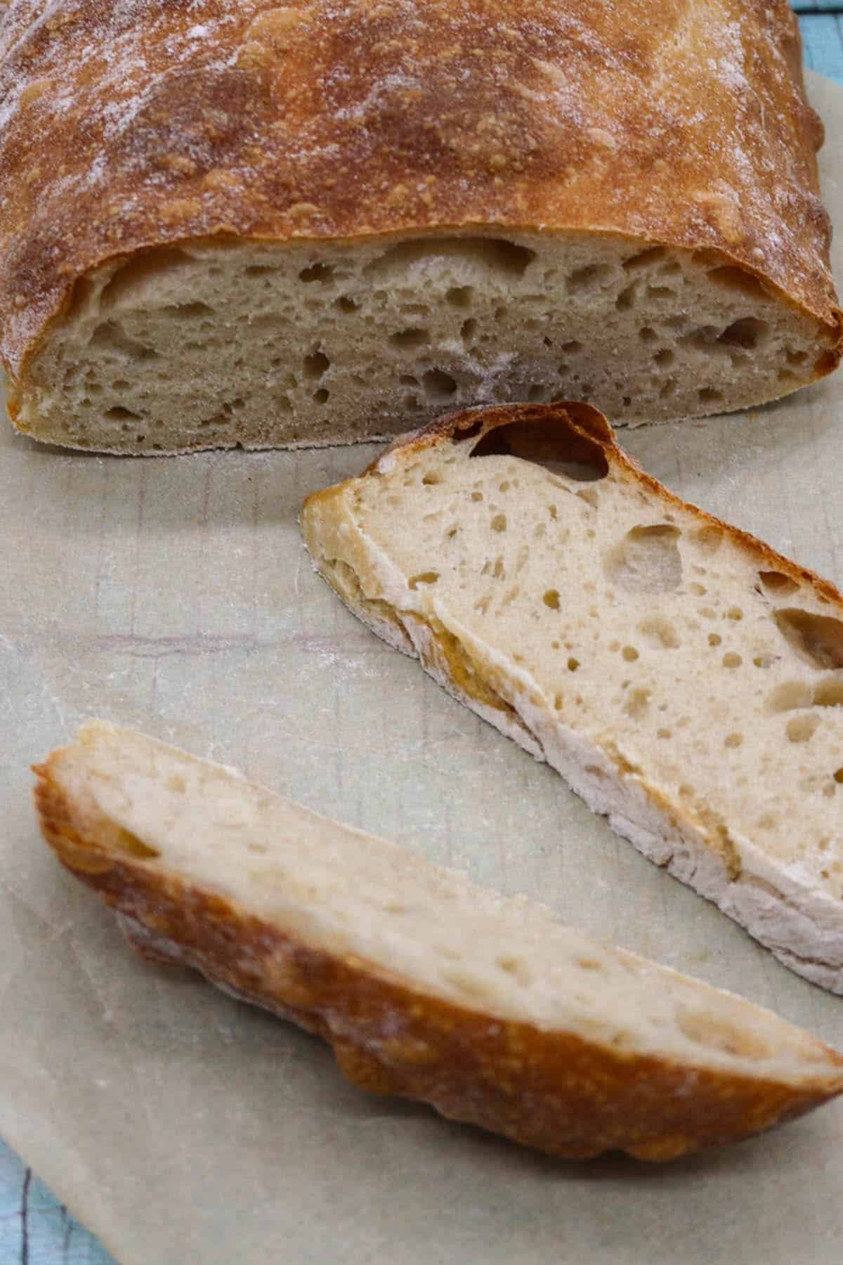 Ciabatta bread sliced on baking paper