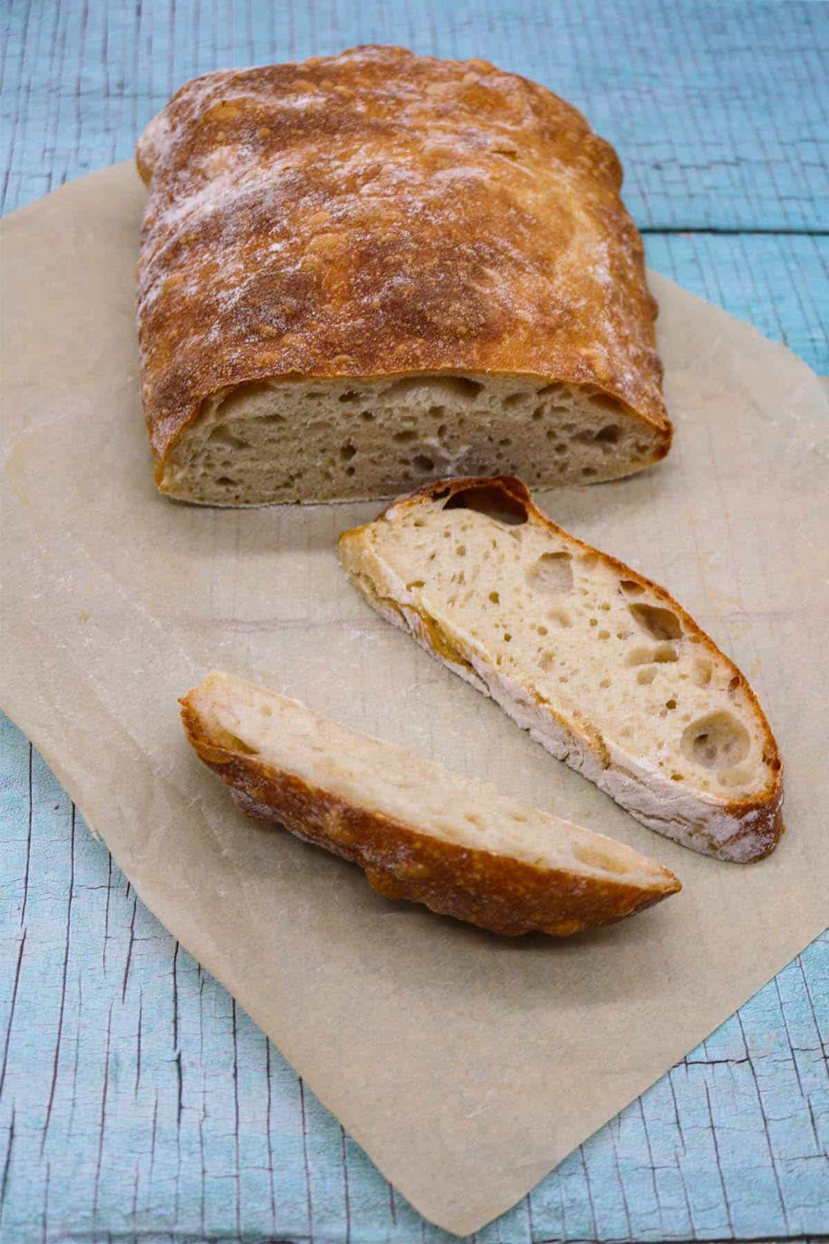 Ciabatta bread sliced on baking paper