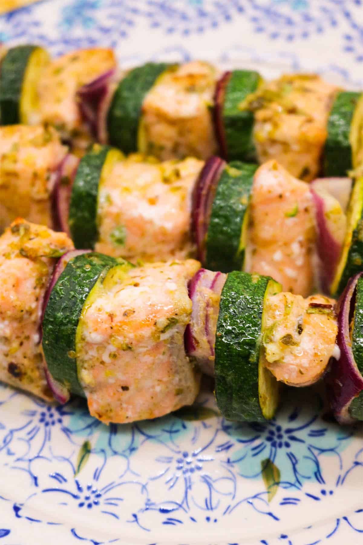 Mediterranean salmon kebabs on a blue and white plate