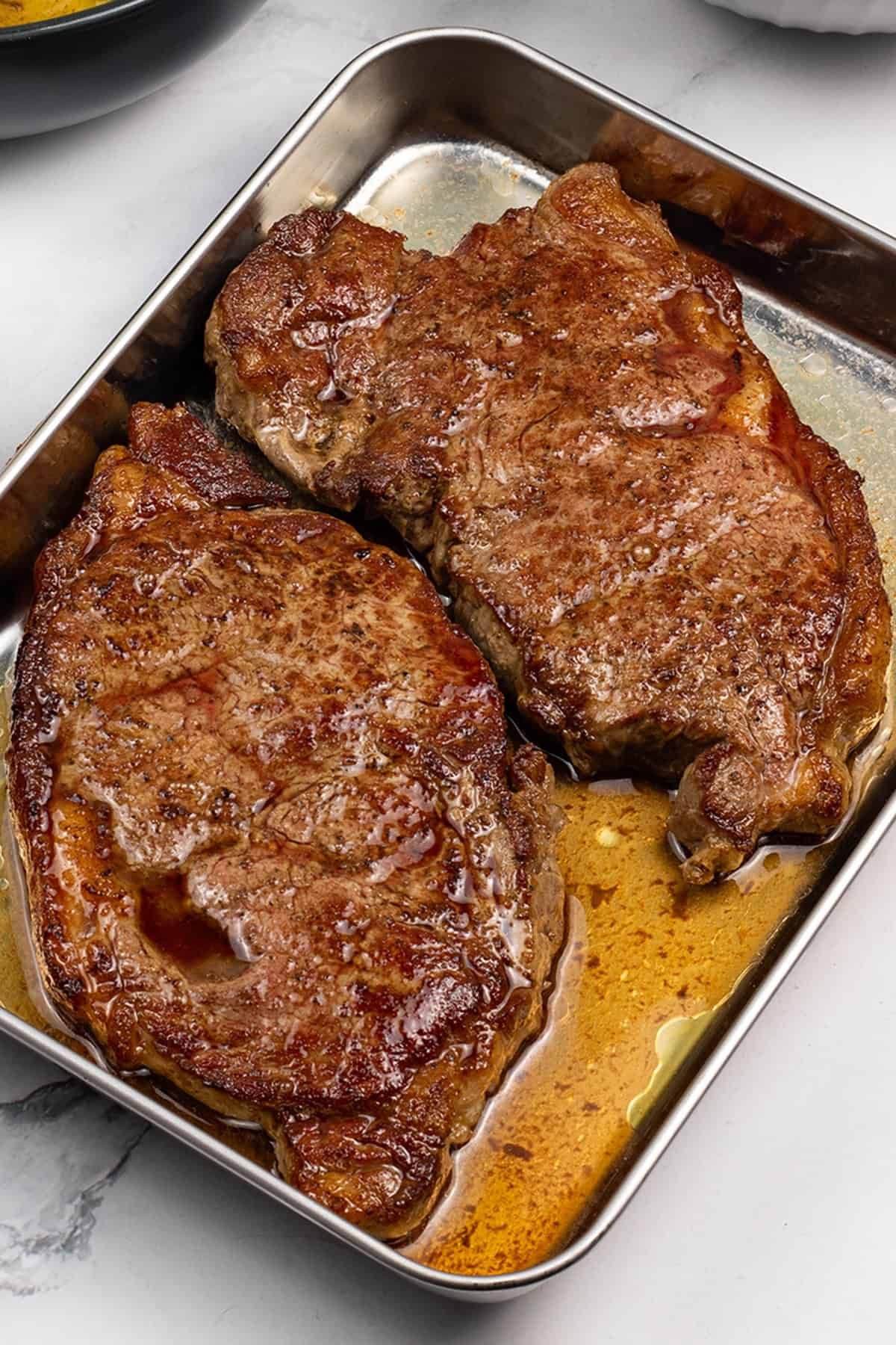 Perfect sirloin steaks resting on a tray.