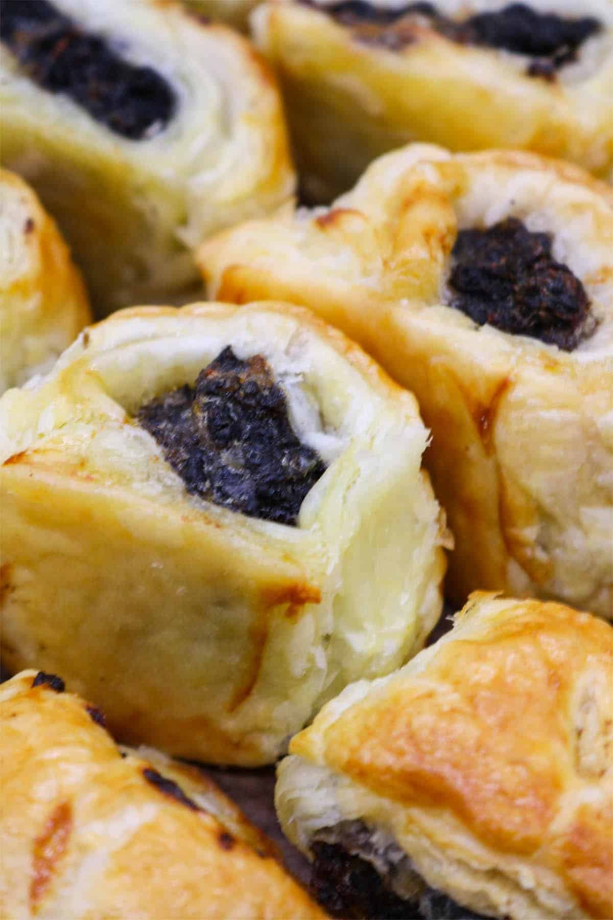 Pork and black pudding sausage rolls on wooden board