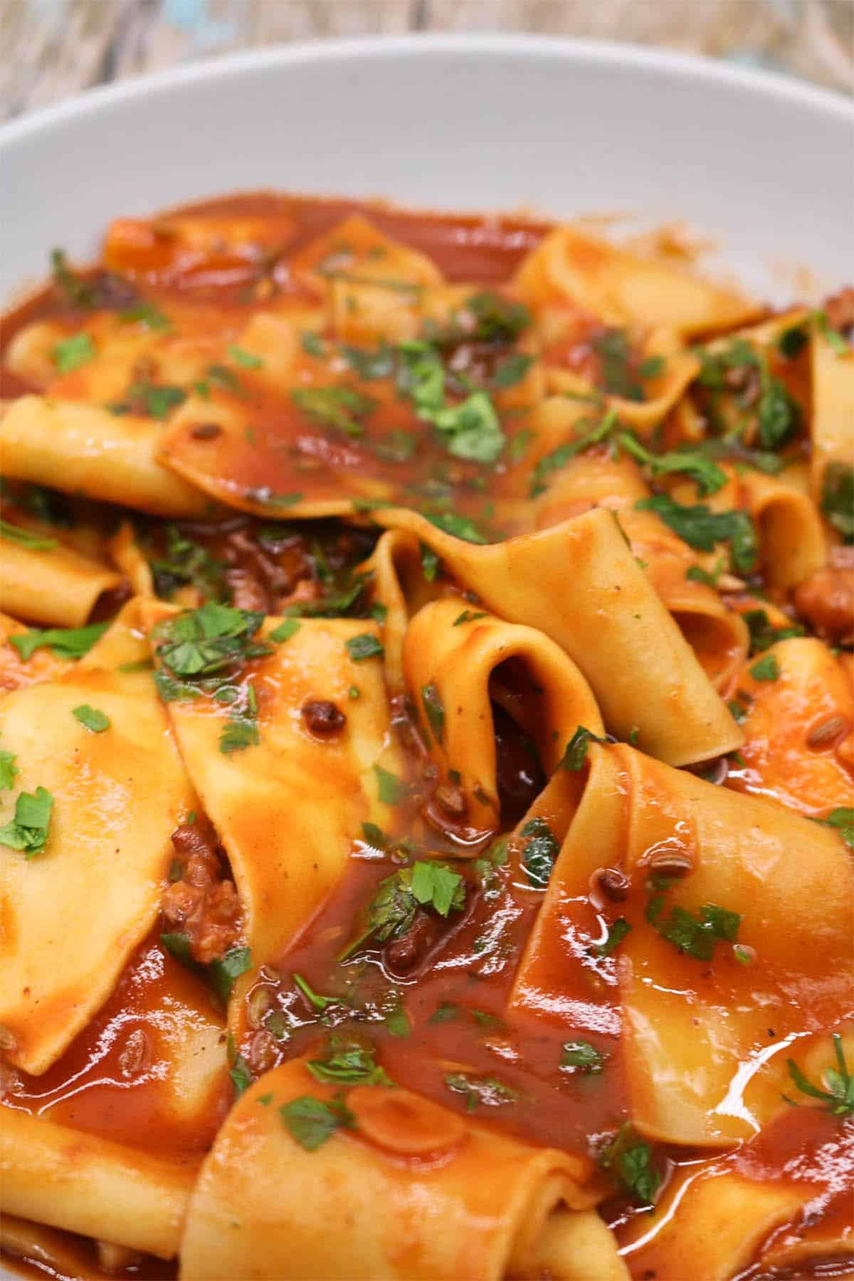 Sausage and pappardelle pasta in grey bowl