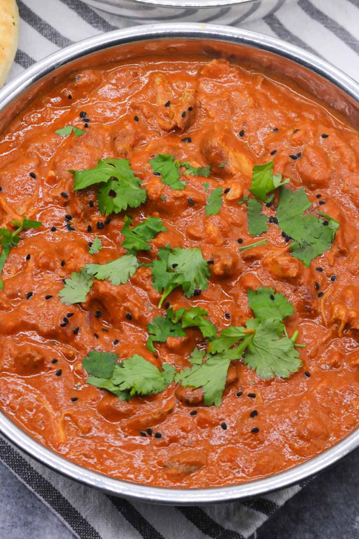 Slow cooker chicken tikka masala in balti dish with coriander and nigella seeds