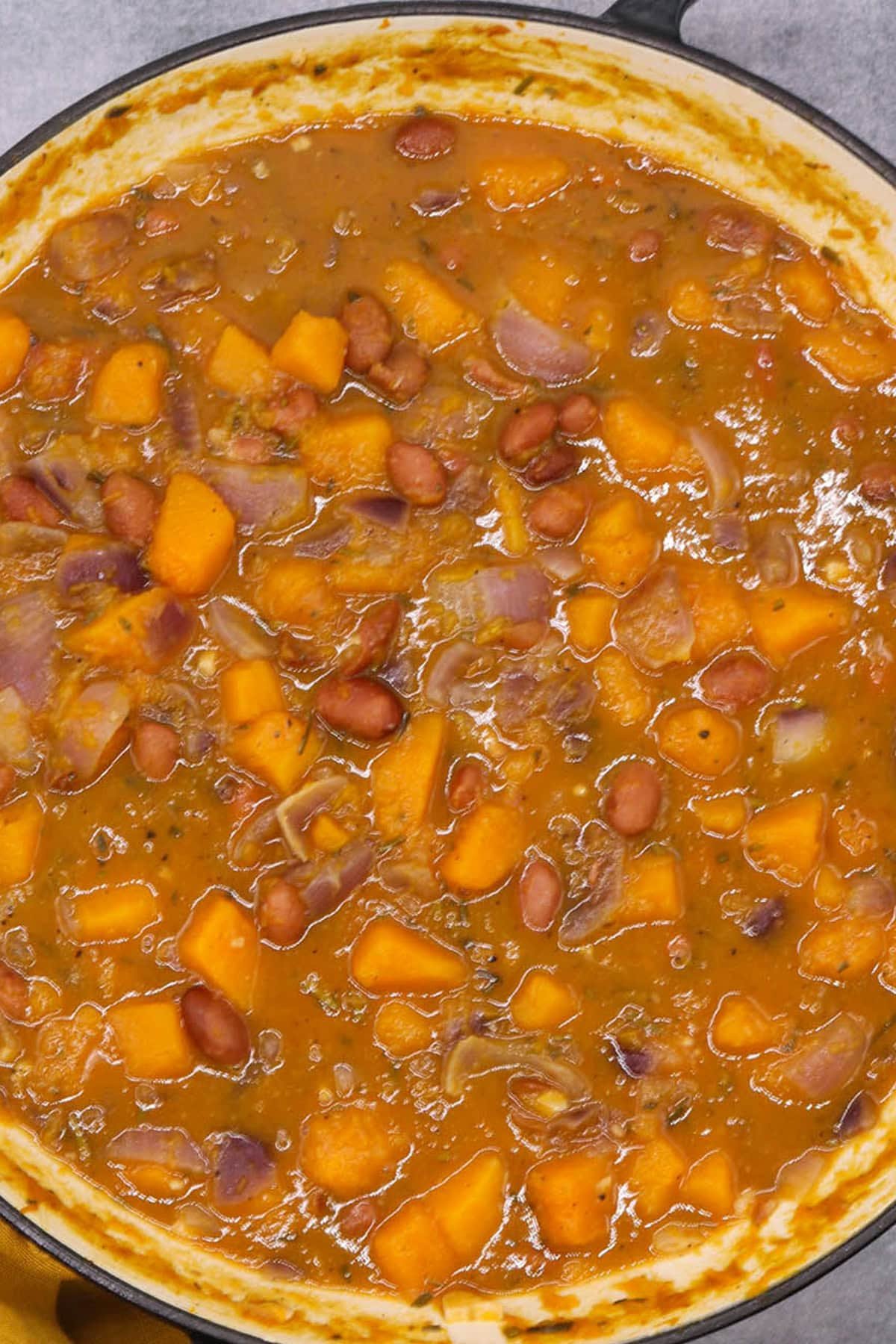 Sumptuous squash soup in a large round casserole with mustard napkin on one handle.