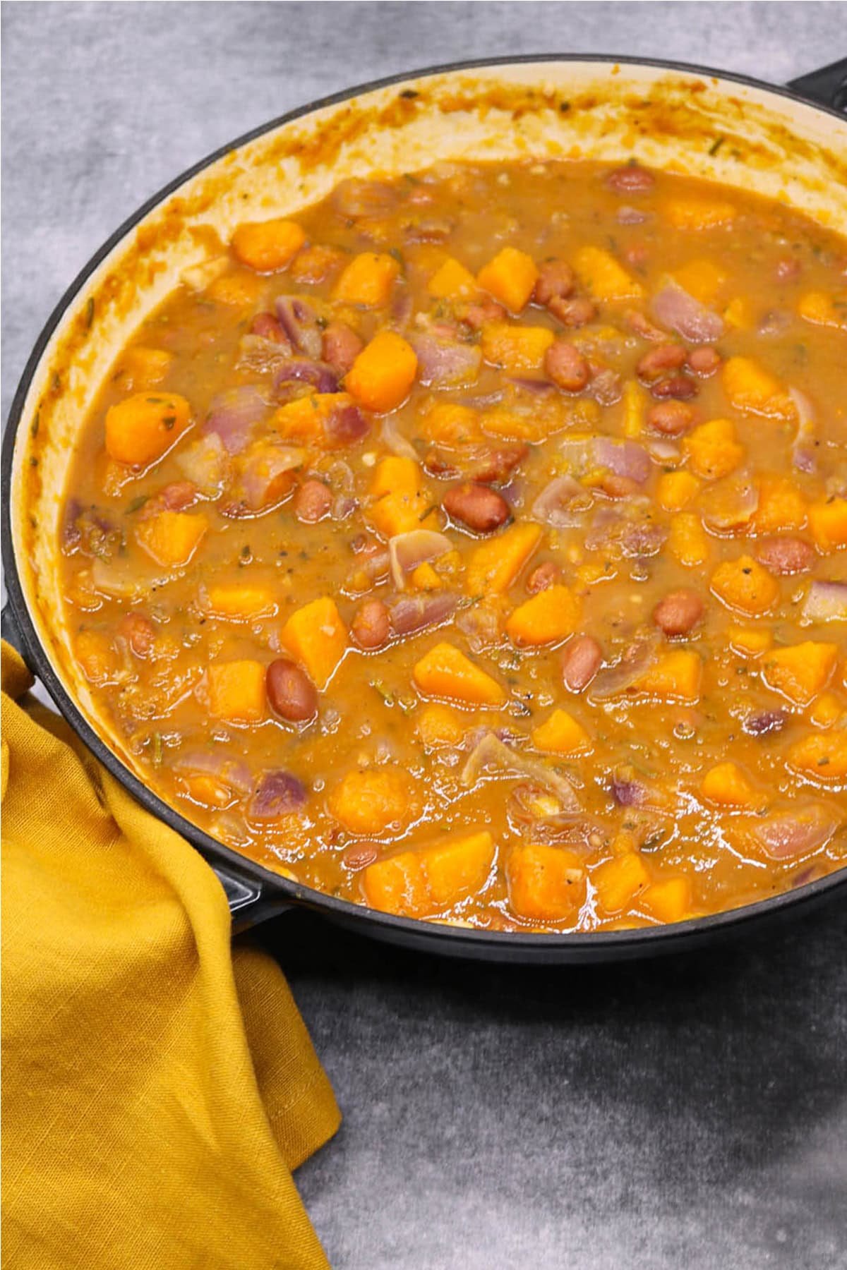 Sumptuous squash soup in a large round casserole with mustard napkin on one handle.