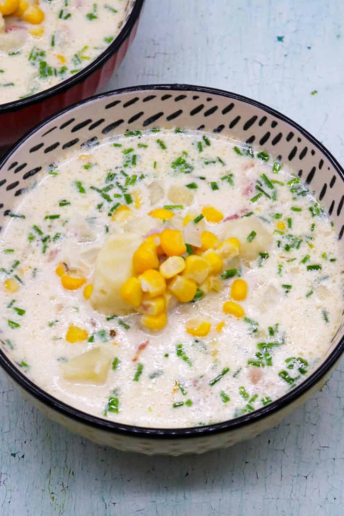 Bacon and sweetcorn chowder in black and white patterned bowls.