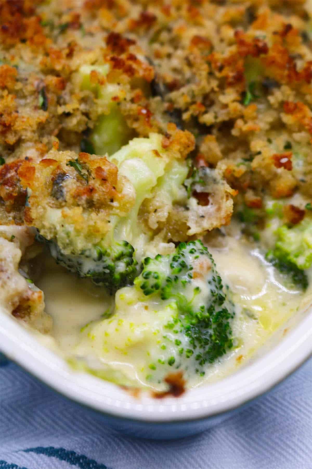 Broccoli and stilton crumble in a rectangle Staub oven dish sitting on a white and teal towel.