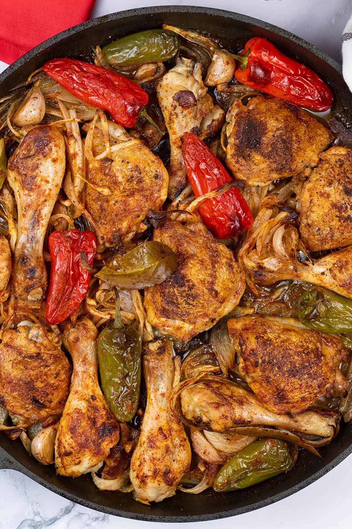 Close up of paprika roast chicken in a large frying pan.