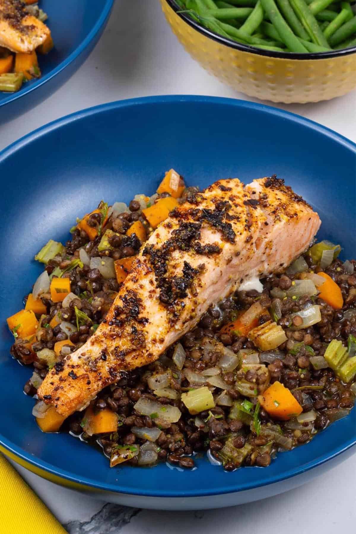 Two bowls of salmon with vegetable puy lentils, plus a dish of quick green beans on the side.