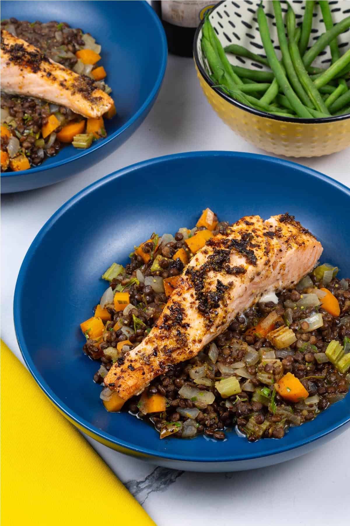 Two bowls of salmon with vegetable puy lentils, plus a dish of quick green beans on the side.