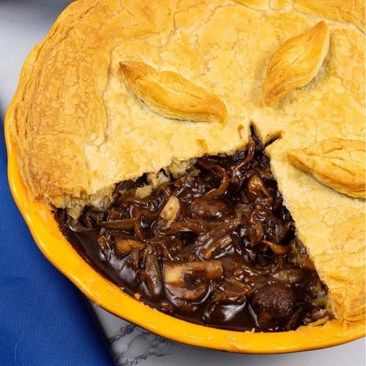 Mushroom and Guinness pie in a round yellow pie dish.