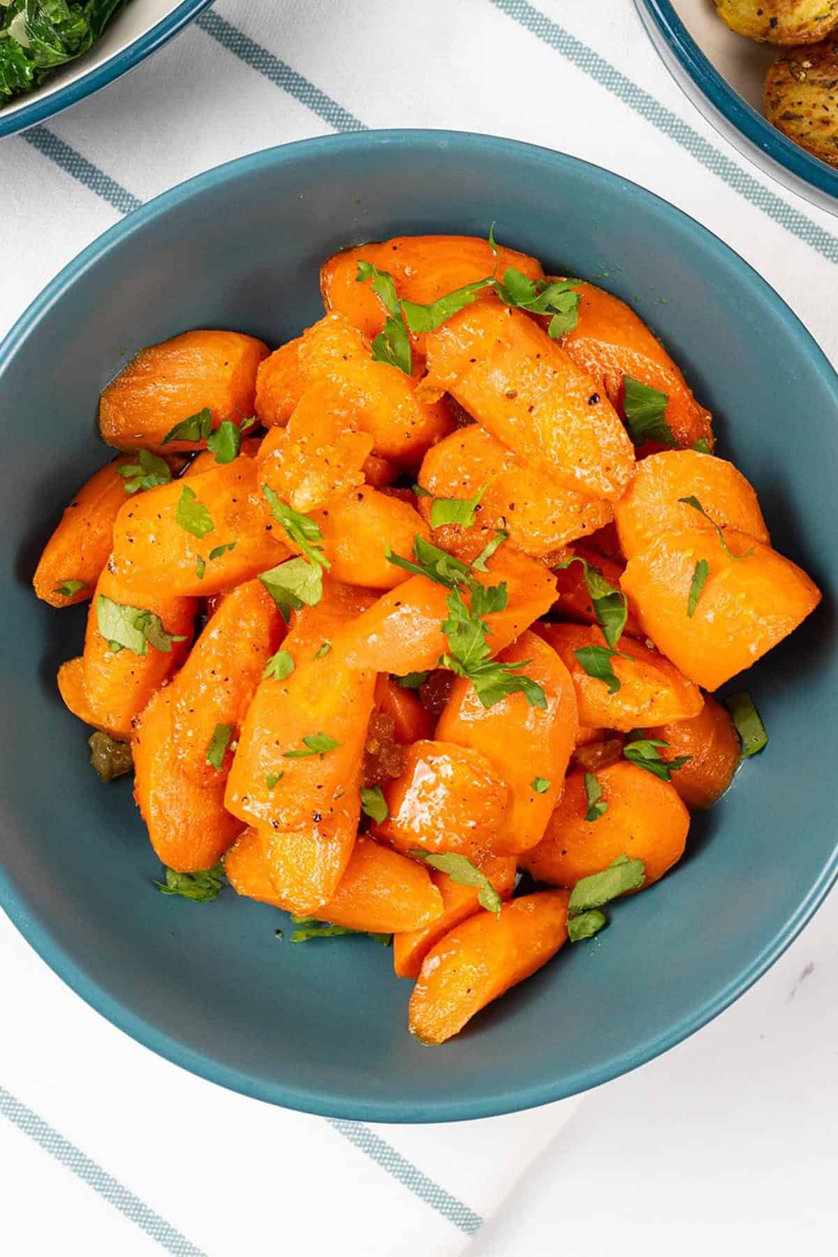 Marmalade roast carrots in a teal serving bowl.
