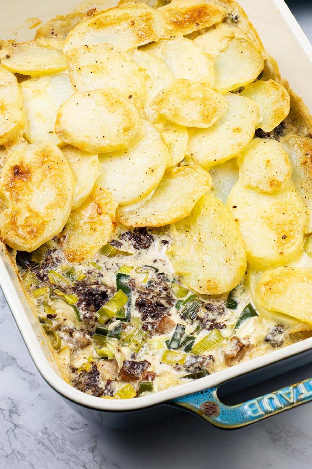 Smoked haddock, black pudding and leek gratin in a rectangle Staub dish.