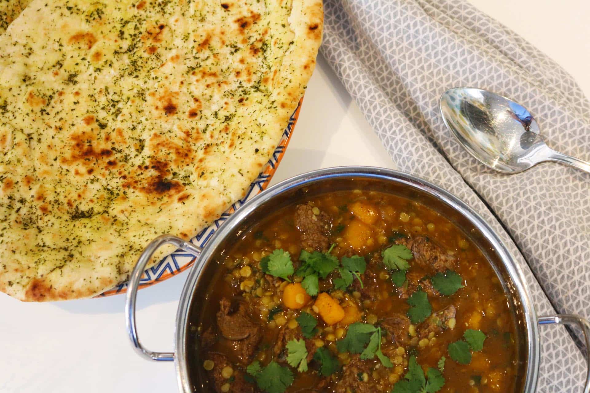 Dhansak in a balti dish with large naan bread on the side