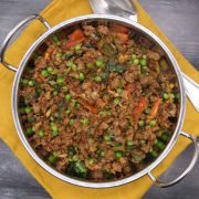 Venison keema in balti dish sitting on yellow napkin with serving spoon