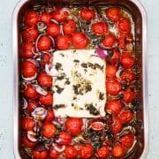 Baked feta with tomatoes in rectangle oven tray
