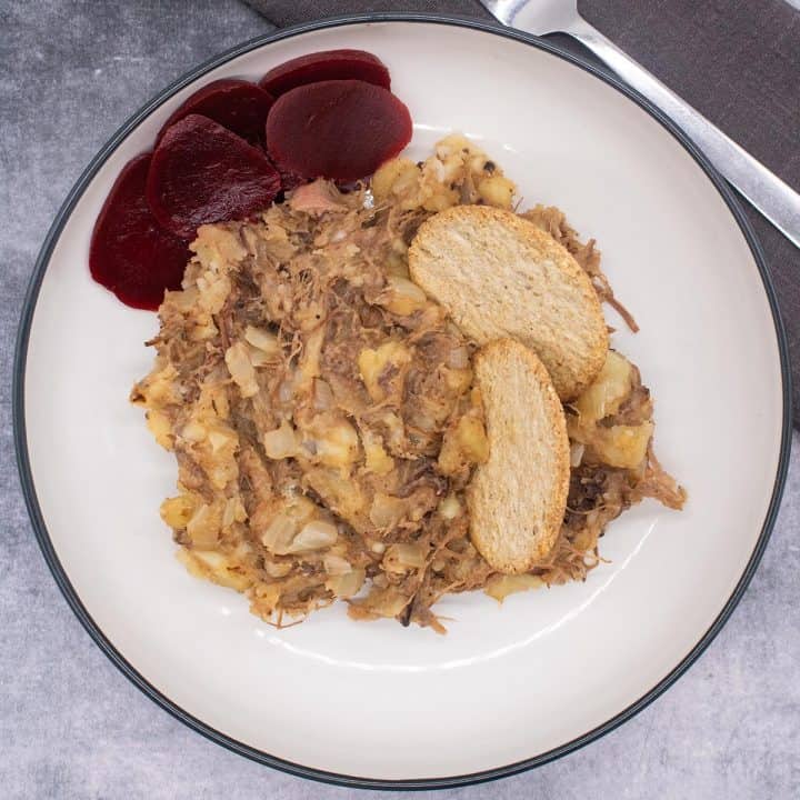 Stovies on a white plate with beetroot and oat cakes