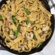 Tarragon chicken and asparagus mafalde in a large black skillet pan