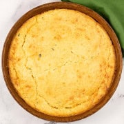 Easy homemade cornbread in a round stoneware dish with a green napkin on the side.
