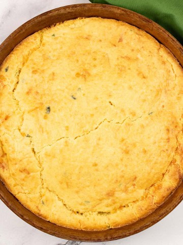 Easy homemade cornbread in a round stoneware dish with a green napkin on the side.