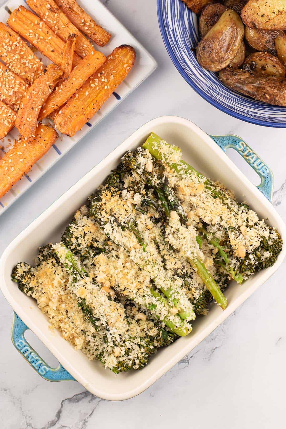 Roast tenderstem broccoli with parmesan and pine nut crumb in a Staub dish with za'atar carrots and sautéed potatoes on the side.