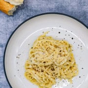 cacio e pepe in bowl with bread in background