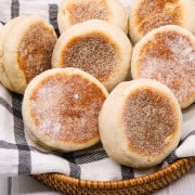 English muffins on black and white towel in bread basket