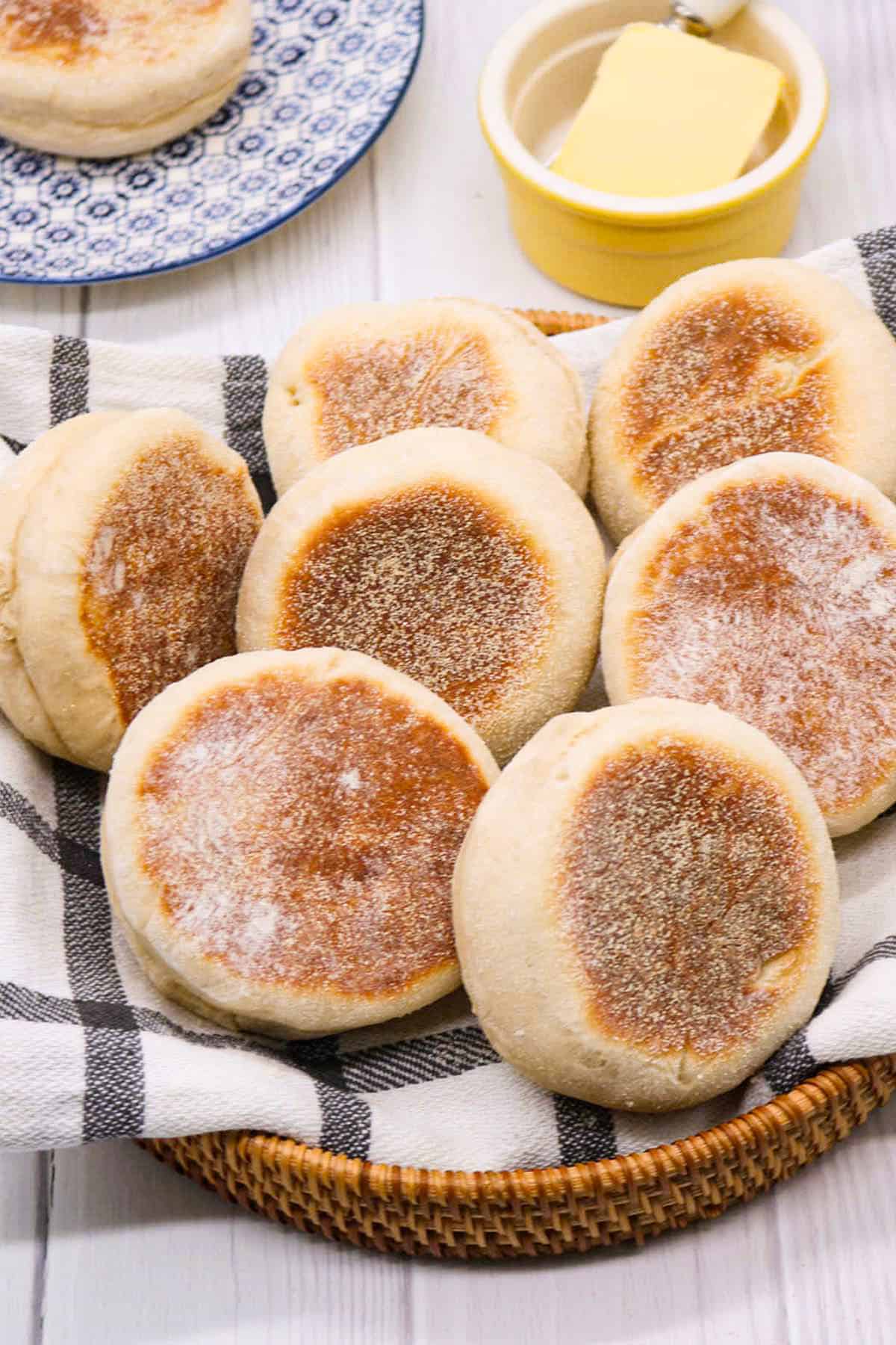 English muffins on black and white towel in bread basket