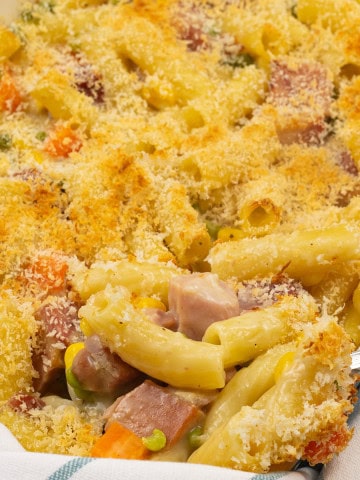 Close up of ham and vegetable pasta bake in a rectangle Staub dish.